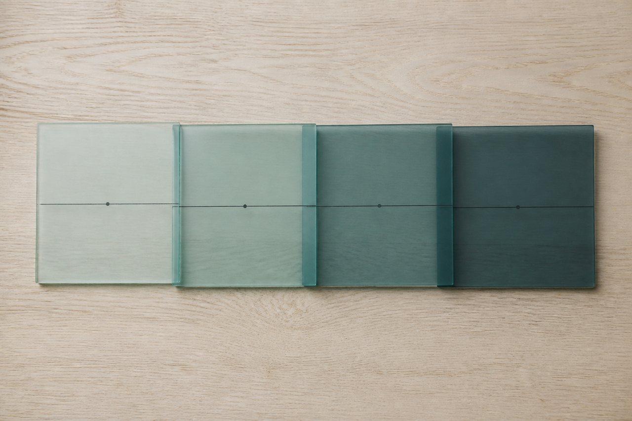 Four overlapping glass sheets in sequence, joined by a single line