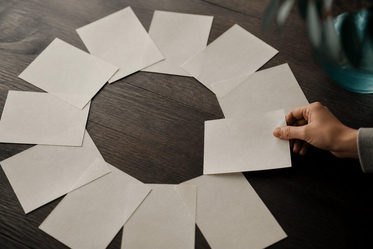 A hand closing a loop of overlapping paper sheets